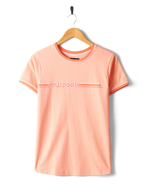 An Retro Ribbon - Womens Shorts Sleeve T-Shirt in Peach with the word "outlook" and retro stripes on the chest, hanging on a black hanger against a white background. Brand Name: Saltrock