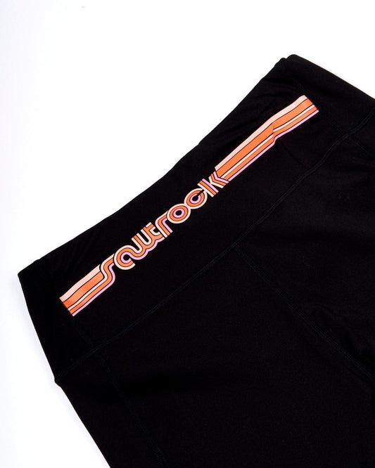 The back of a Saltrock Retro Ribbon - Womens Leggings - Black with an orange stripe made of soft fabric.