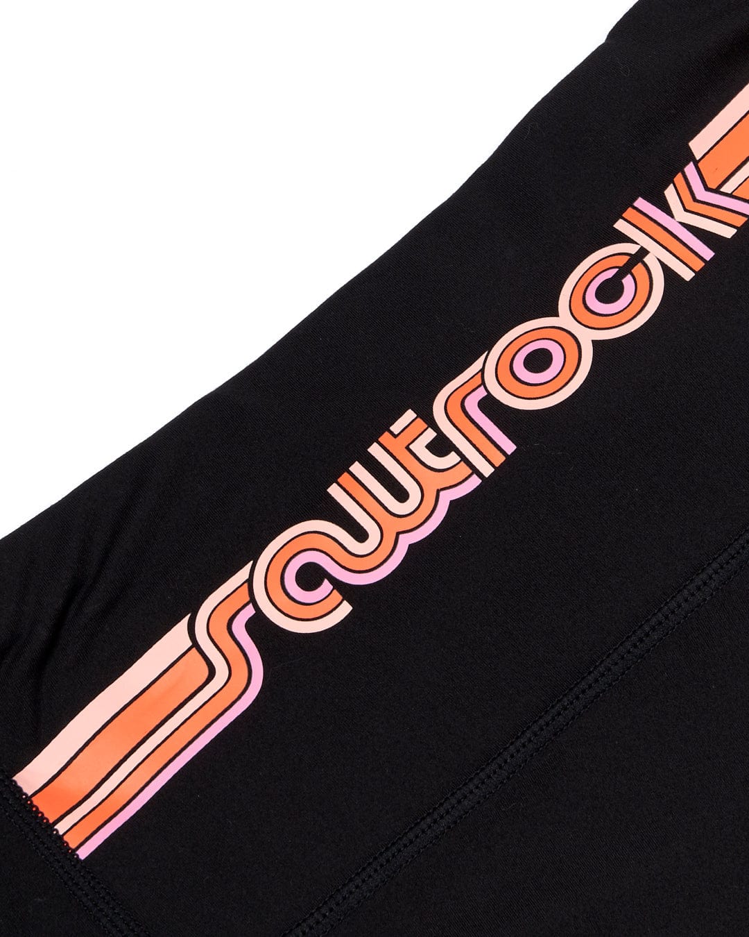 A pair of Saltrock Retro Ribbon - Womens Leggings in black with a retro print logo in pink and orange.