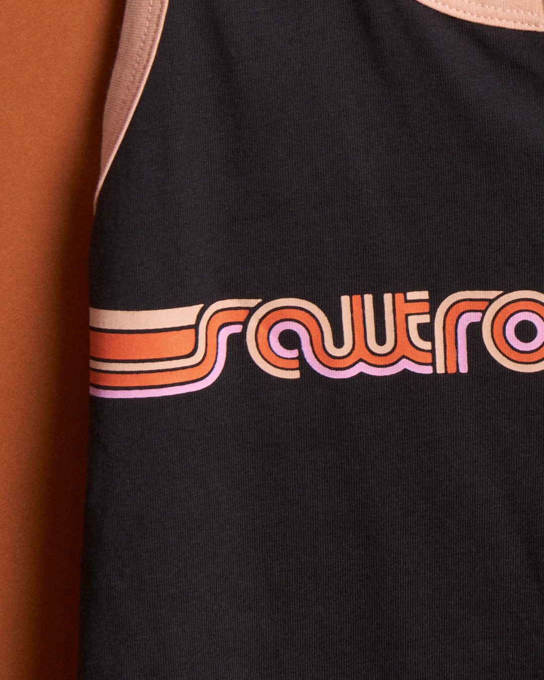 Close-up of a Saltrock Retro Ribbon - Womens Vest - Dark Grey tank top with the word "power" printed in stylized orange and pink retro font, partially visible, featuring a retro ribbon stripe.