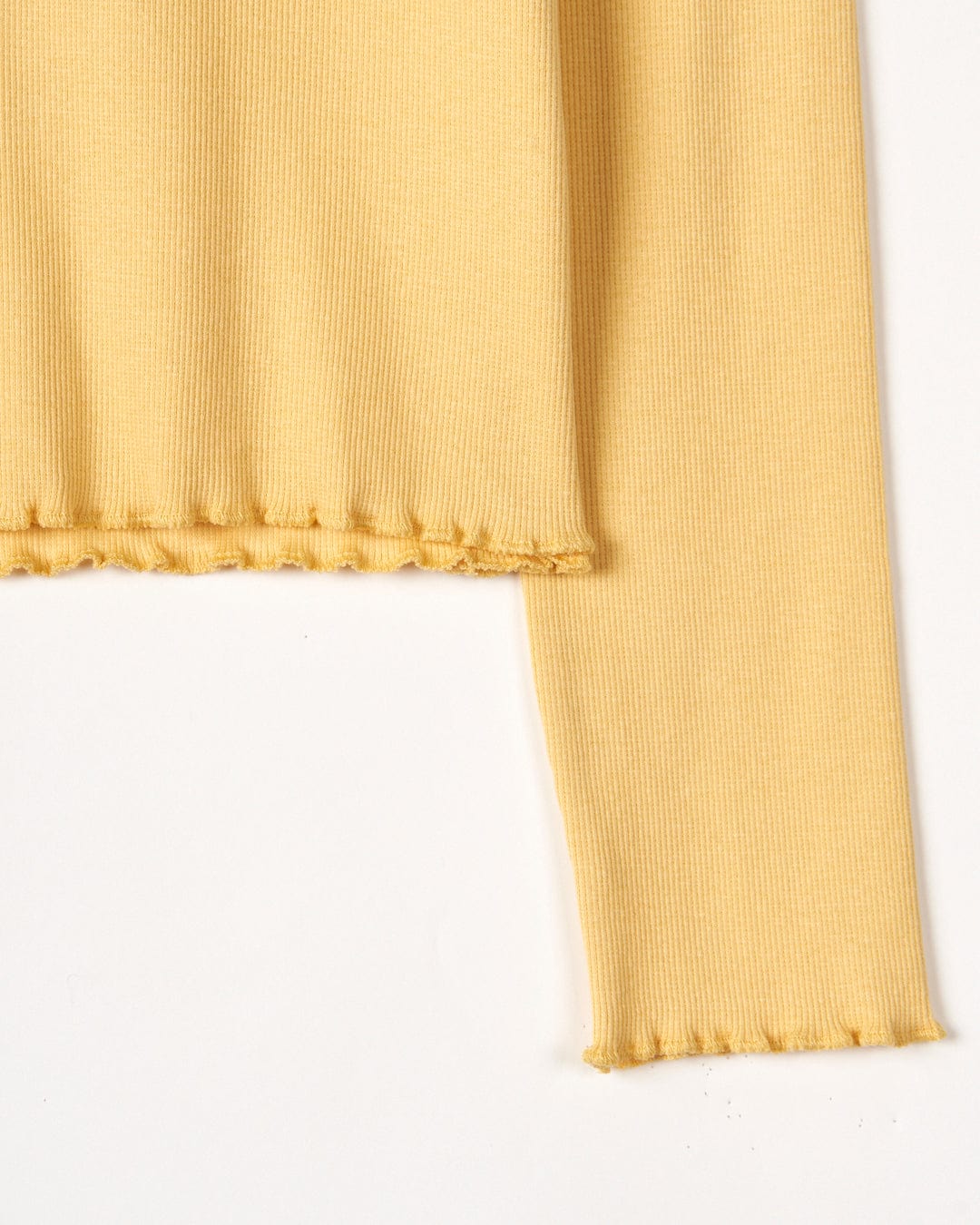 A close up of a Saltrock Retro Seascape - Kids Long Sleeve T-Shirt in Yellow with a frilled hem.