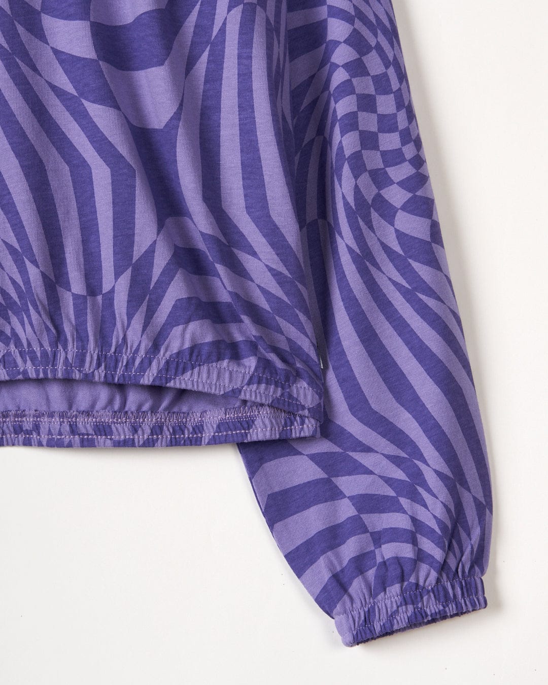 Close-up of a Saltrock Rezz - Recycled Kids Lightweight Pop Hoodie - Purple with an elastic hem, featuring a Warp print, displayed on a plain background.