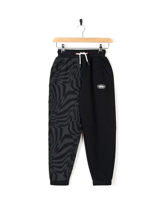 A stylish Rip It - Kids Jogging Bottom - Black from Saltrock hanging on a hanger.