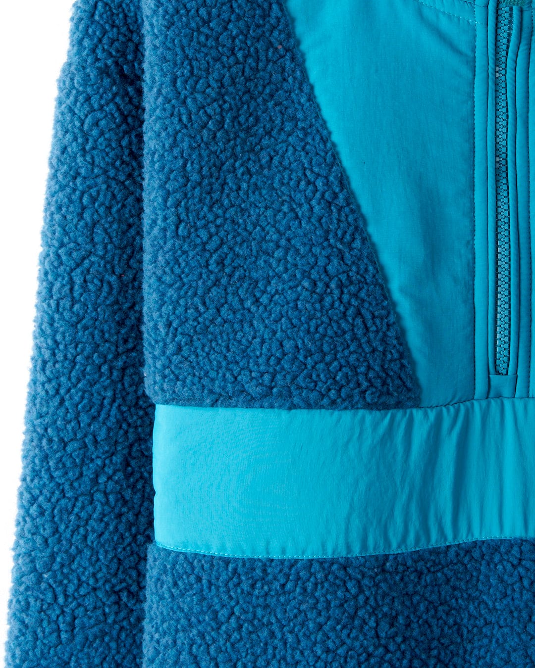 Close-up of the Saltrock Robyn Women's Fleece in blue, featuring cosy sherpa fleece, smooth nylon panels, a partial front zip, and subtle Saltrock branding.