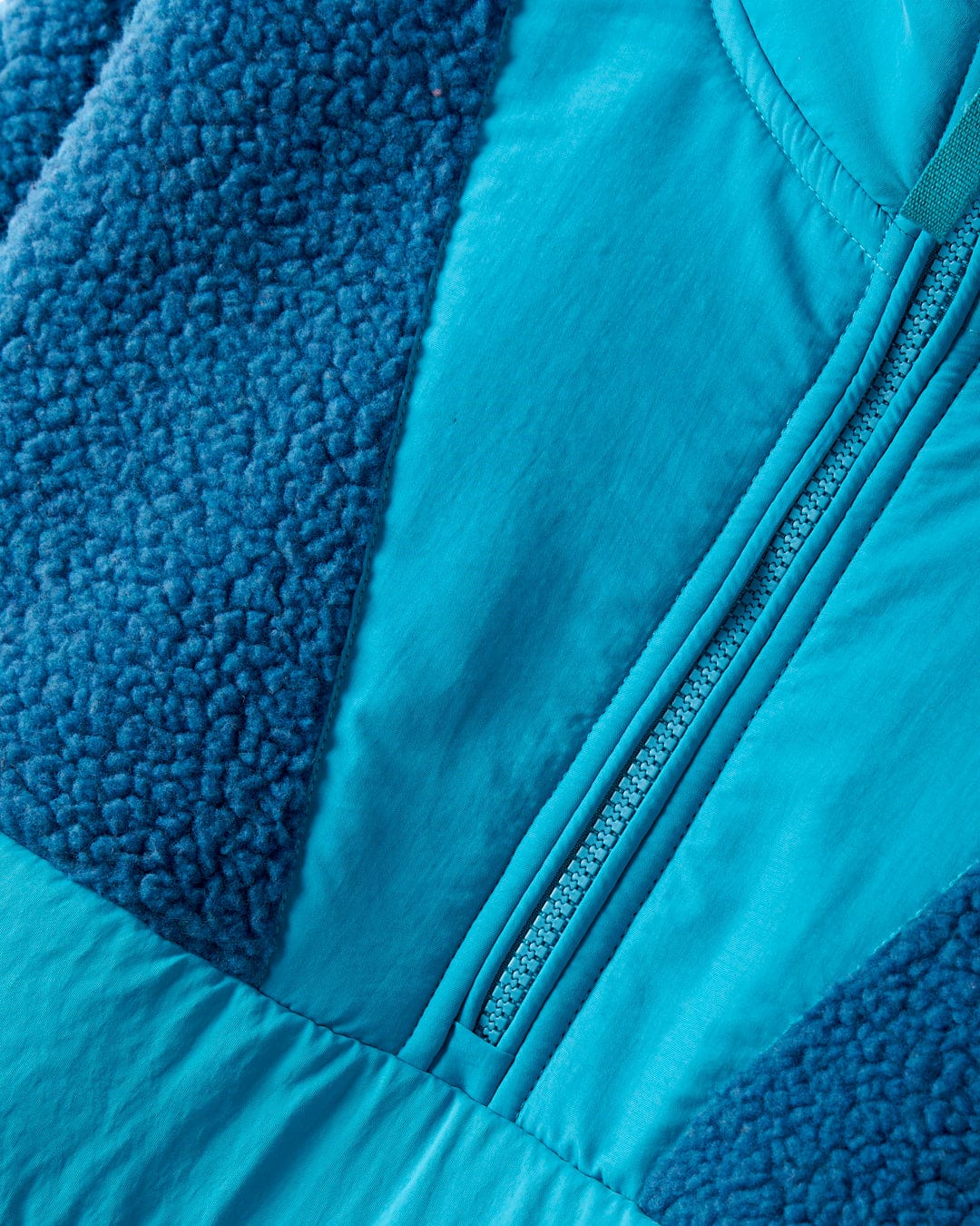 Close-up of the Saltrock Robyn Women's Fleece in Blue, showcasing cosy fleece material, a central zipper, and textured fabric details.
