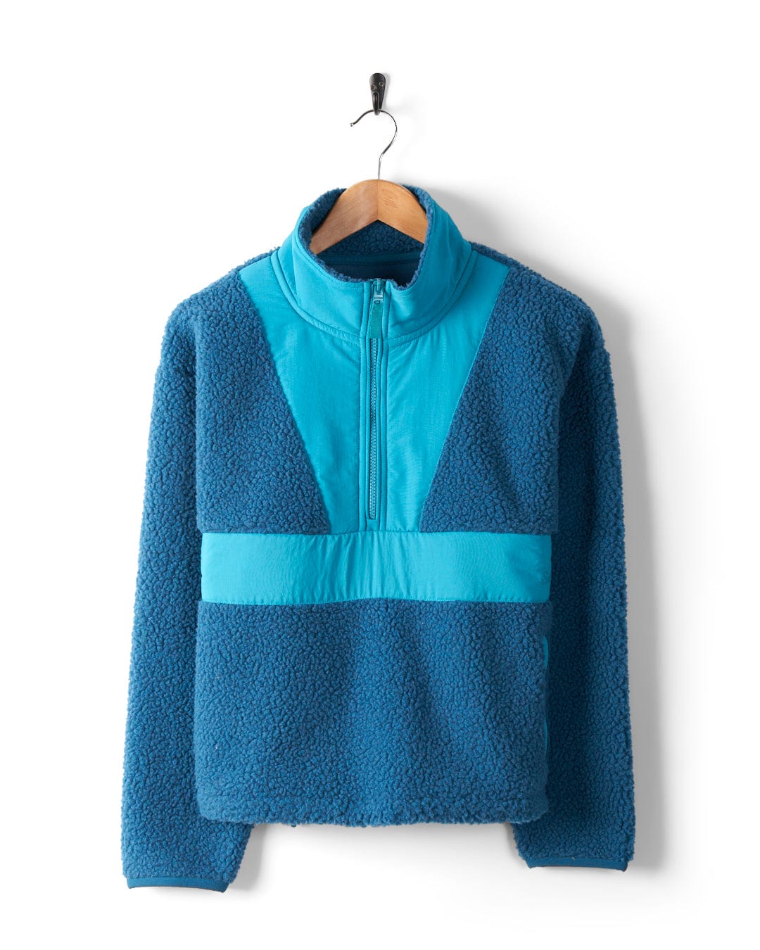 The Saltrock Robyn Women's Fleece in blue features a cosy fleece material, high collar, and half-zip front. It is displayed on a wooden hanger against a white background.