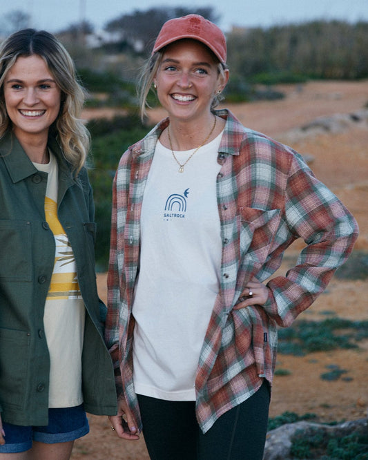 Two smiling women posing outdoors dressed in casual attire, one wearing a Saltrock Rosalin Womens Long Sleeve Shirt in Orange/green with contrasting buttons made from lightweight fabric.