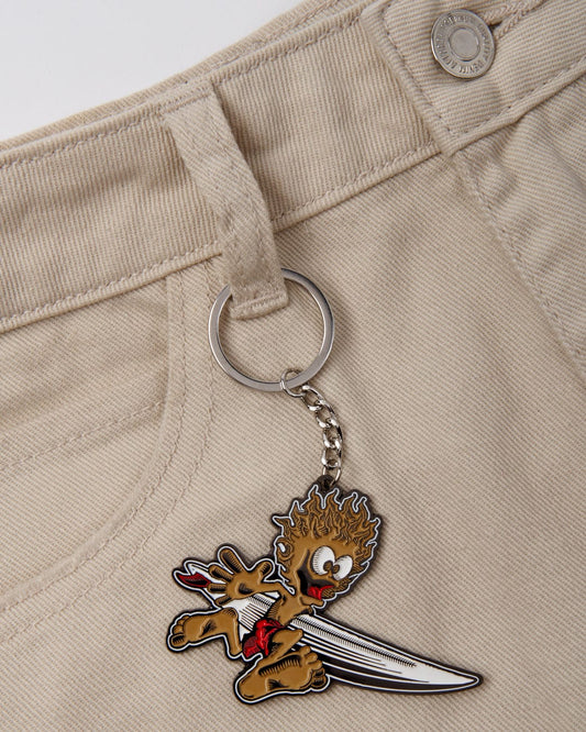 Keychain with Saltrock Running Man key ring character attached to beige pants.