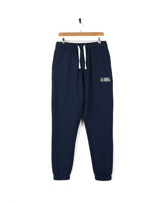 Saltrock - Mens Original 20 Jogger - Dark blue, a pair of navy sweatpants known for their comfortable and relaxed fit, hanging on a hanger.