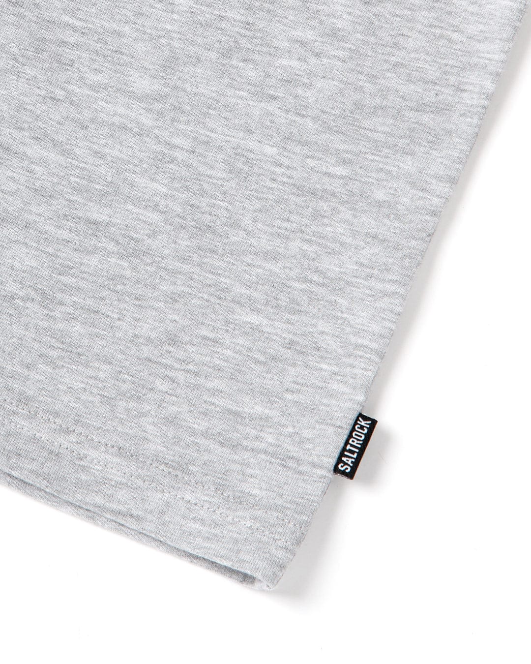 A close-up of a soft, gray fabric with a fine texture, featuring a small black and white Saltrock branding label on the lower right corner of the Saltrock Original - Mens Short Sleeve T-Shirt - Grey.