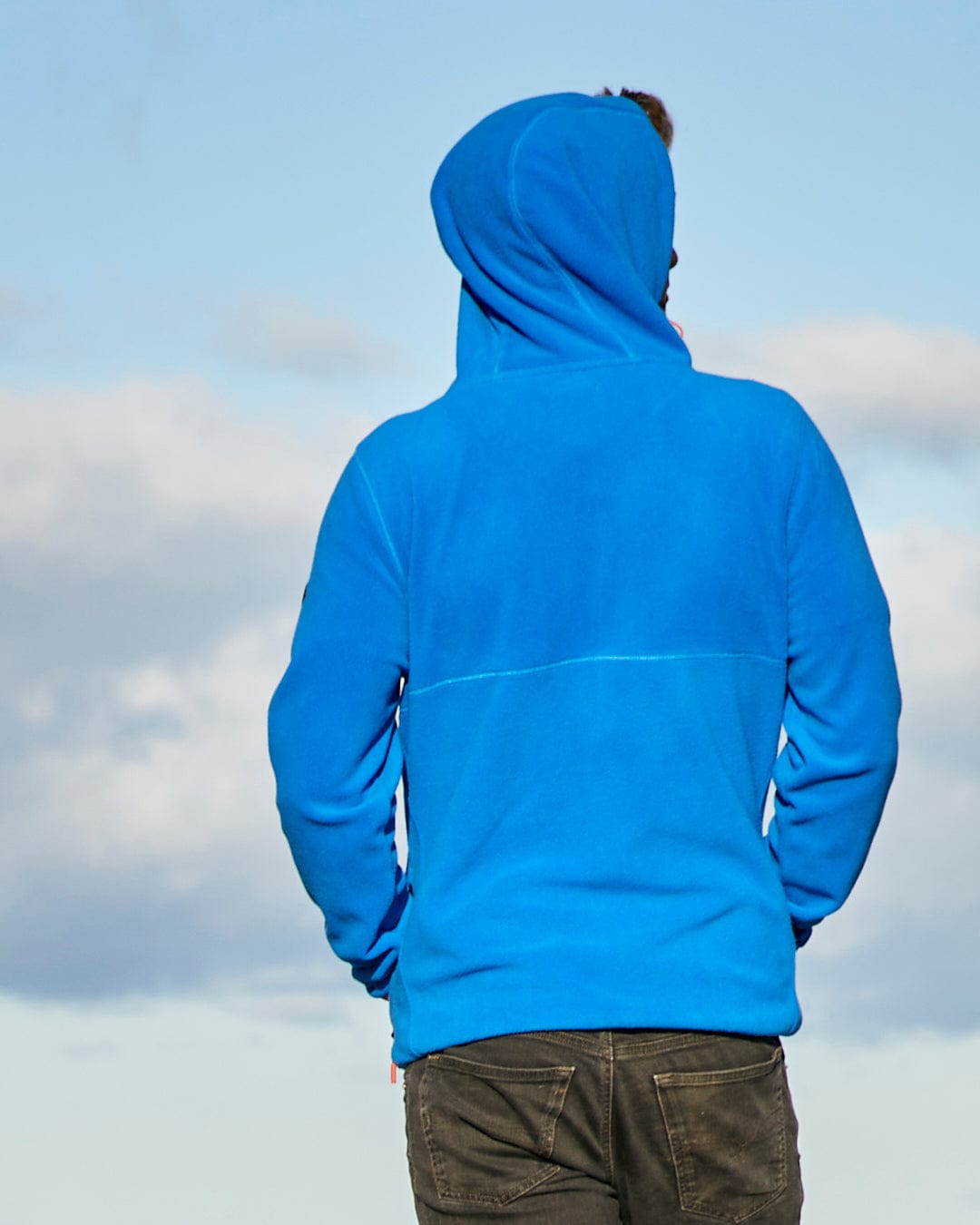 A man wearing a Senja - Mens Fleece Hoodie - Blue with Saltrock branding.