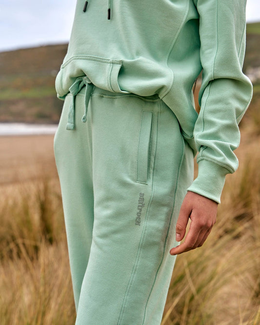 A woman wearing a Saltrock Shelley - Womens Jogger - Light Green hoodie and sweatpants.