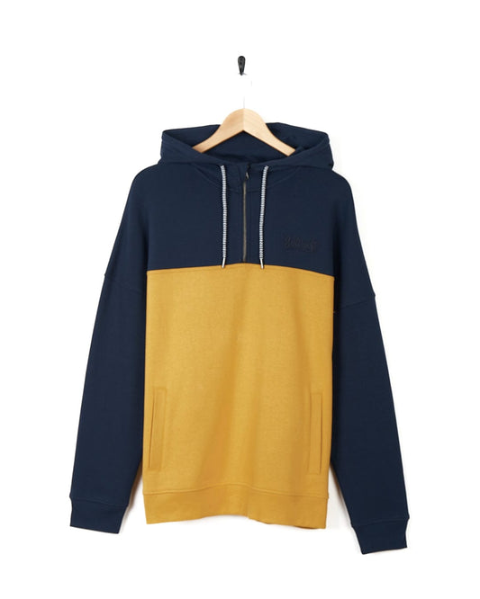A Saltrock Speed Embroidery - Mens 1/4 Neck Zip - Blue/Yellow hoodie hanging on a hanger.
