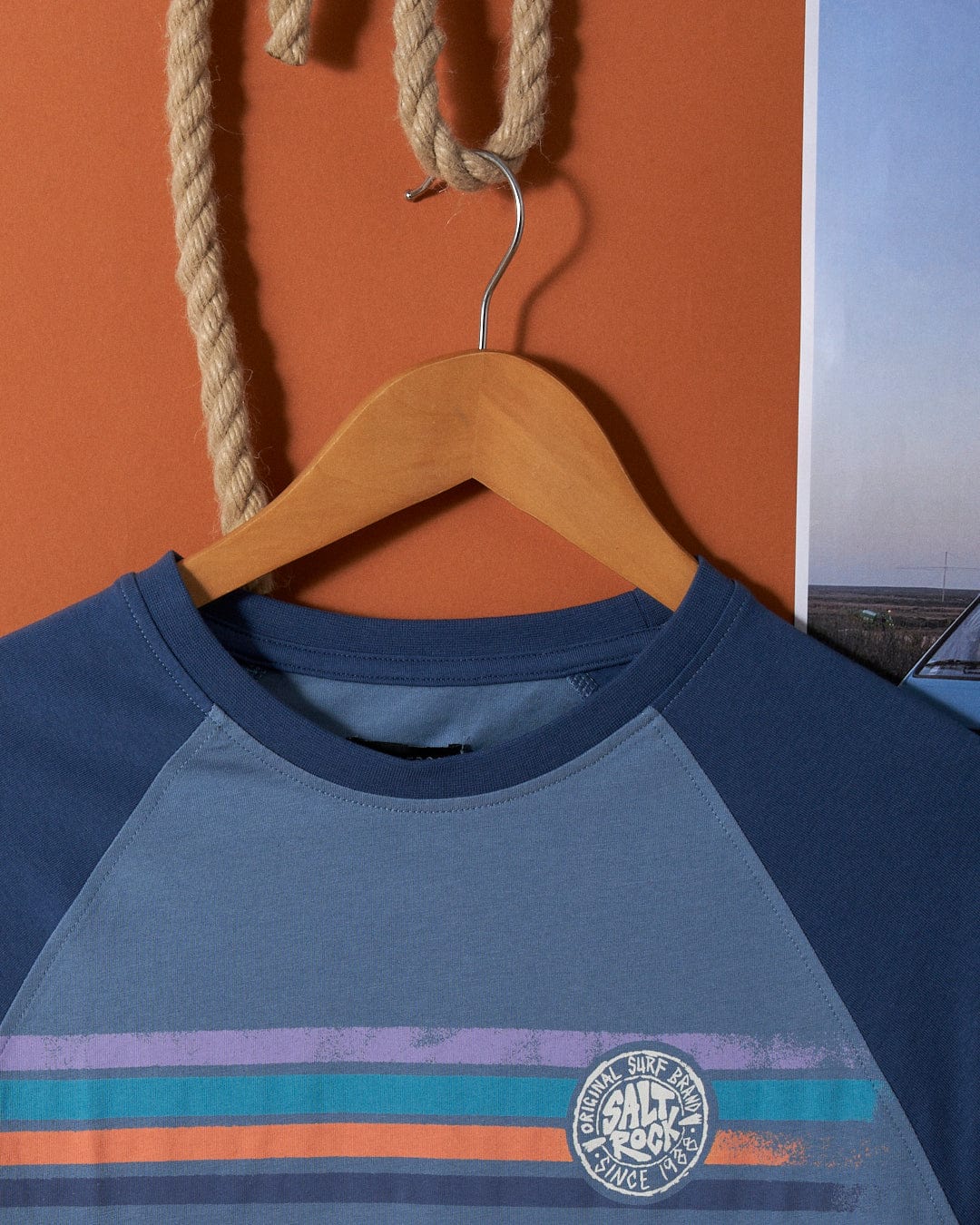 A Saltrock Spray Stripe - Mens Long Sleeve T-Shirt - Blue hanging on a rope.