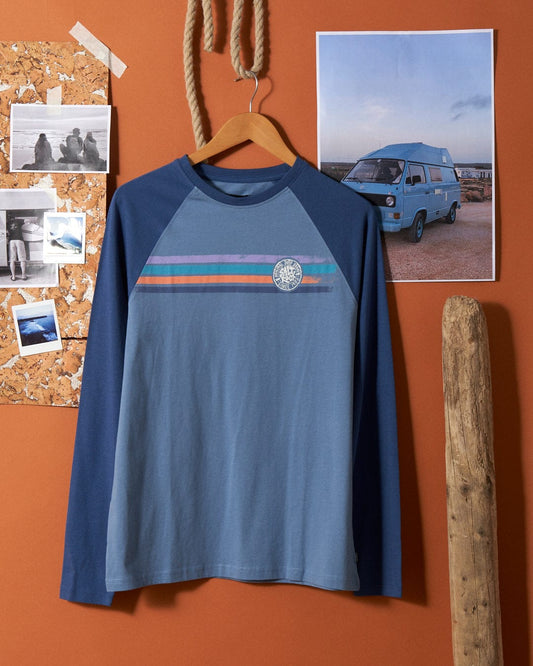 A Spray Stripe - Mens Long Sleeve T-Shirt - Blue made by Saltrock hanging on an orange wall.
