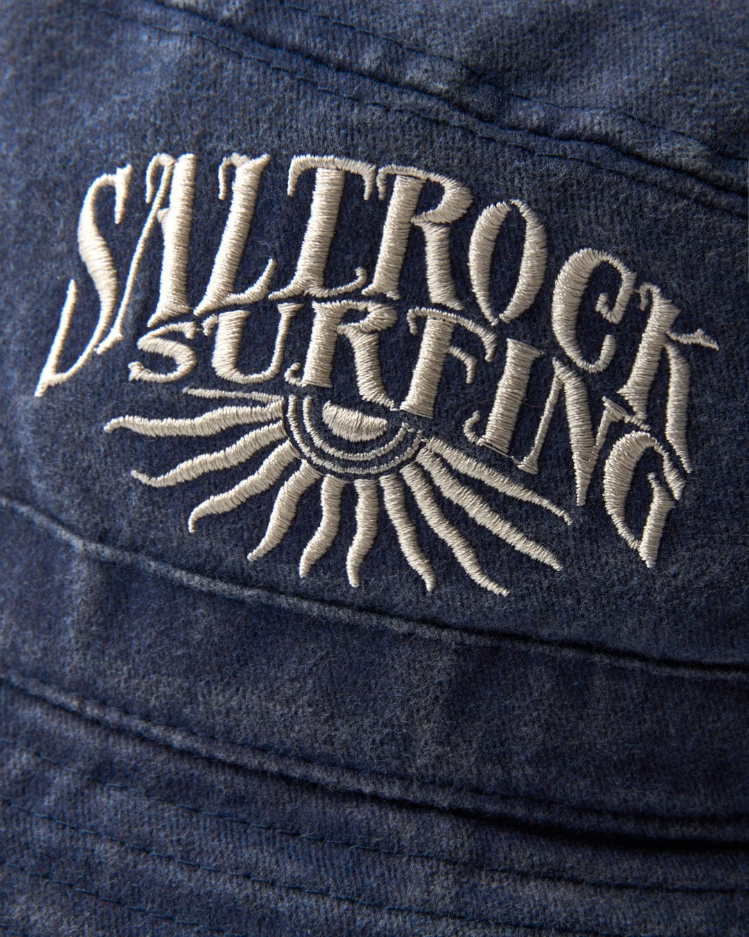 Embroidered Sunburst Bucket Hat - Dark Blue branding with sun design on blue fabric featuring ventilation.