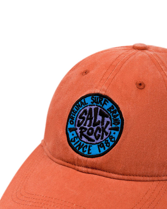 Burnt Orange baseball cap with Saltrock surf brand branded badge on a white background and an adjustable strap.