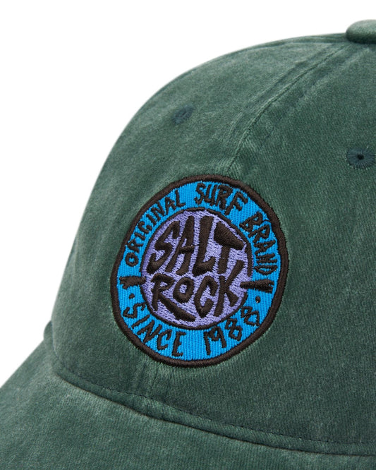 Close-up of a SR Original Cap - Green with an embroidered "Saltrock original surf company since 1983" logo patch featuring an adjustable strap.
