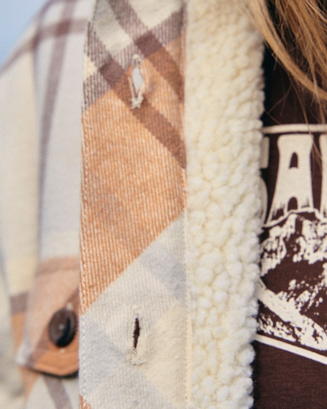 A close up of a woman wearing a Saltrock Stella - Womens Checked Borg Lined Shacket - Cream.