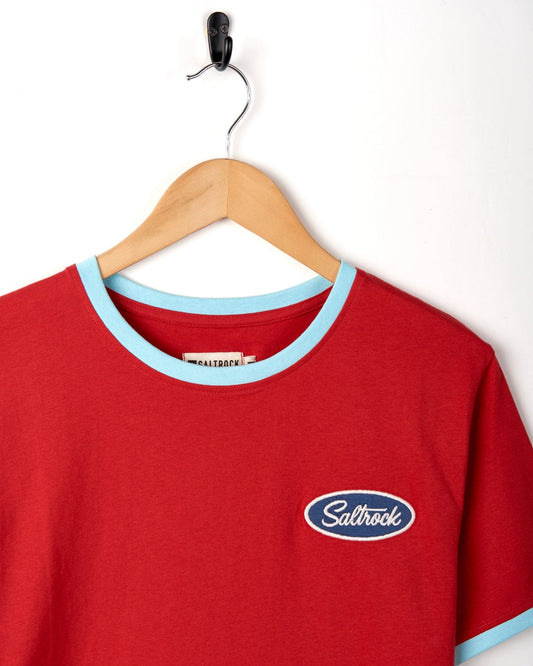 Saltrock's Striker Ringer - Mens Short Sleeve T-Shirt - Red with contrasting blue trim is displayed on a wooden hanger against a white background, made from 100% Cotton.