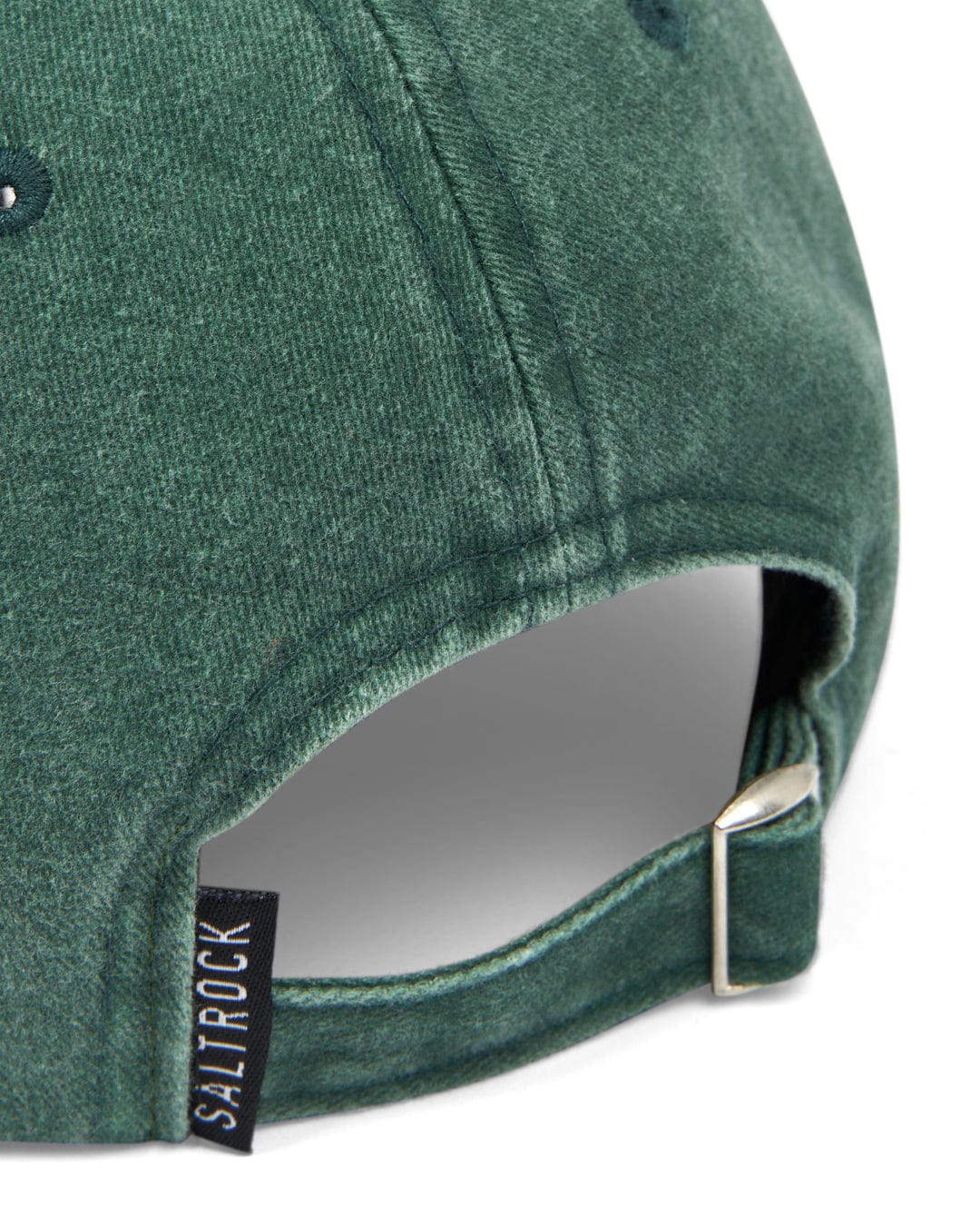 Close-up view of a Saltrock Sunburst Cap - Green with an adjustable strap and metal clasp at the back, featuring a sunburst graphic embroidery on the curved visor and a small black label with white text.