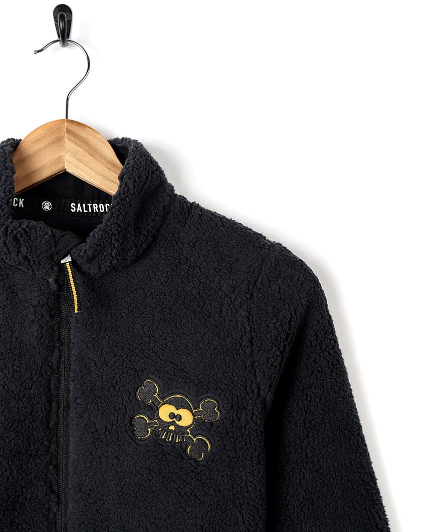 A Tagged - Kids Sherpa Fleece - Black jacket with a skull and crossbones embroidered on it, by Saltrock.