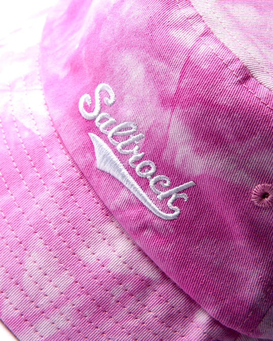 Close-up of a pink cotton fabric Tie Dye Bucket Hat - Pink with the word "Saltrock" embroidered on it.