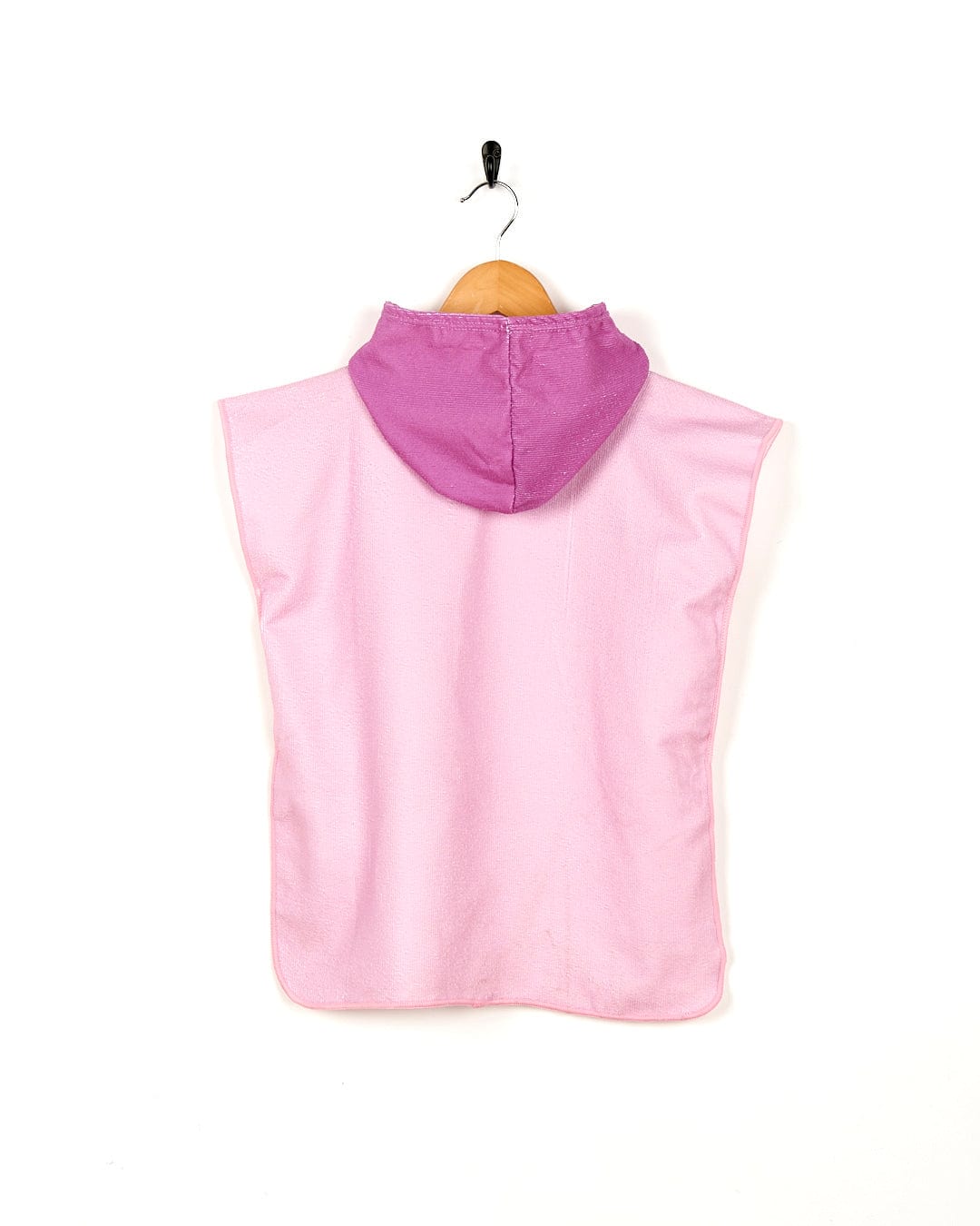 A Tik - Kids Changing Towel - Pink hooded poncho hanging on a wooden hanger by Saltrock.