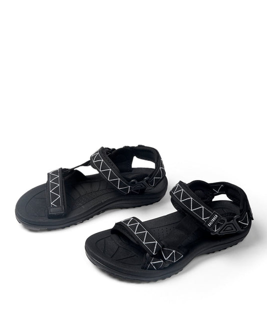 A pair of Tracker - Mens Sandals - Black with adjustable velcro straps and patterned soles on a white background by Saltrock.
