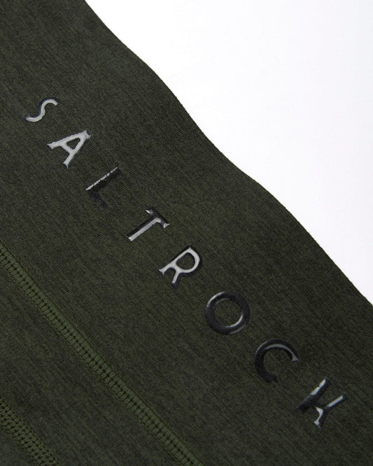 Close-up of a Saltrock dark green fabric with the word "saltrock" embroidered in white, featuring high quality stretch.