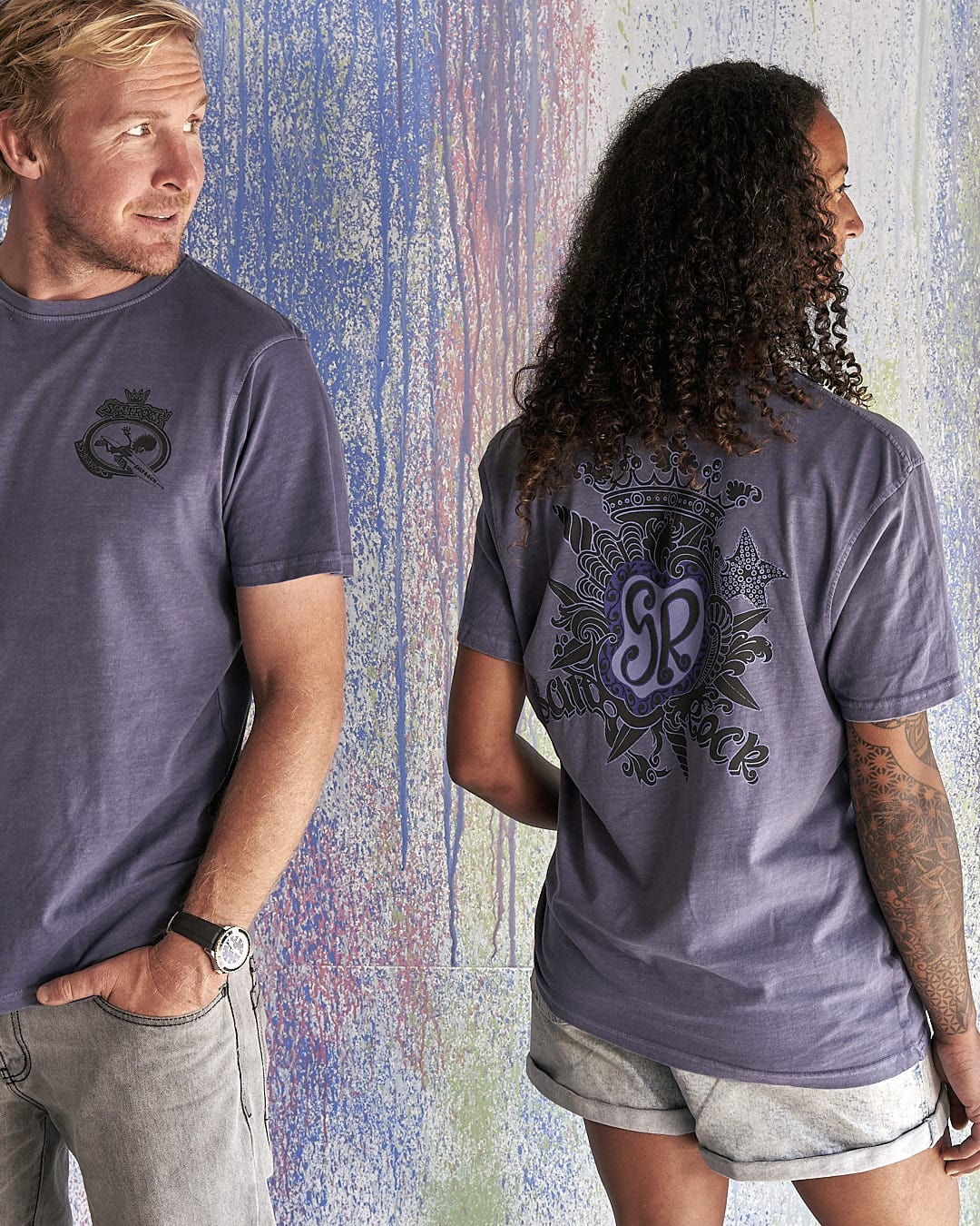A man and woman standing next to each other wearing a Saltrock - Tribal Saltrock Limited Edition 35 Years T-Shirt.