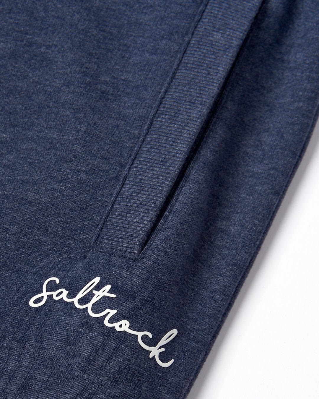 Close-up of a navy blue Velator - Womens Joggers - Blue Marl textile with a stitched Saltrock branding on the elasticated waist.