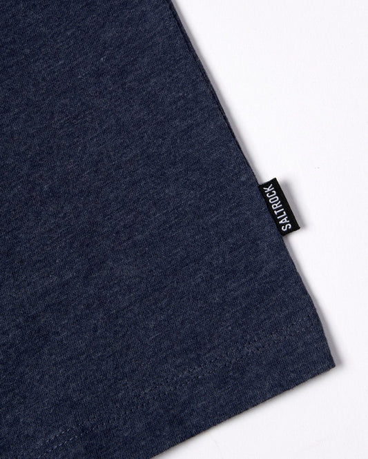 Dark blue fabric texture with a visible woven label stitched on reading "Saltrock" in white letters, on a plain white background.