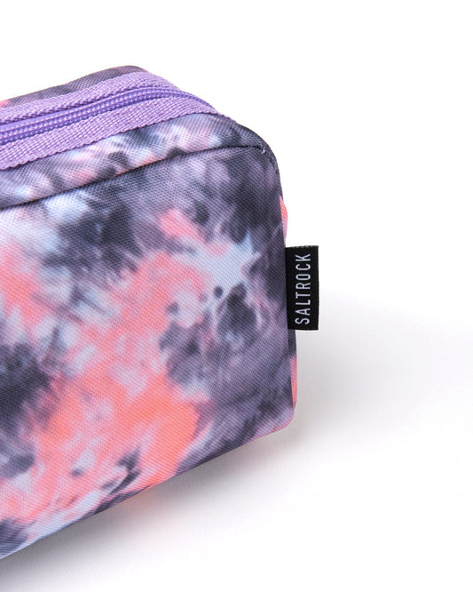 A small, floral-patterned cosmetic bag with hues of pink and purple, featuring visible Saltrock branding on the side.