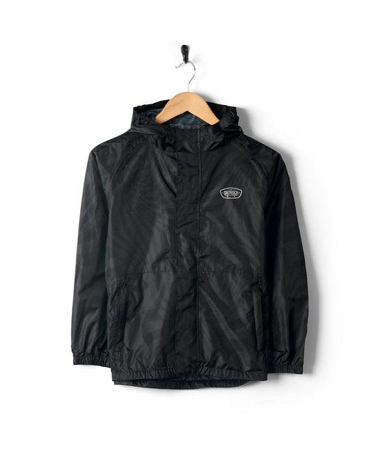 Warped - Kids Waterproof Packable Jacket - Black by Saltrock hanging on a wooden hanger against a white background.