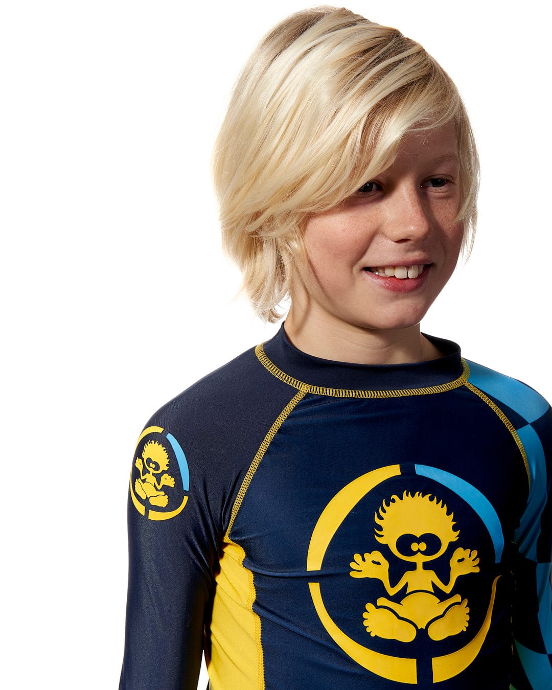 A young boy wearing a Saltrock Warp Kids Long Sleeve Rash Vest in Blue.