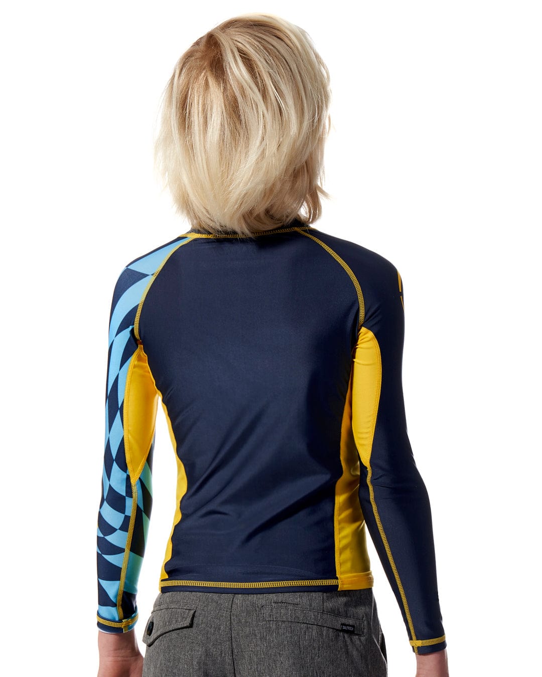 The back view of a woman wearing a Saltrock Warp - Kids Long Sleeve Rash Vest - Blue.