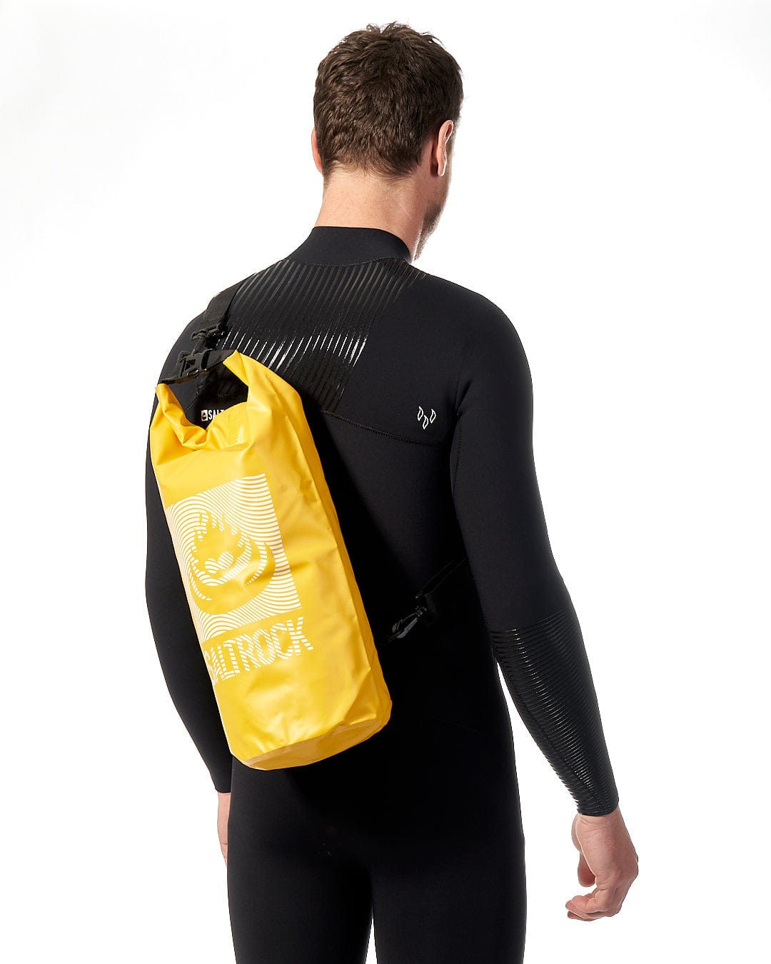 A man in a waterproof wetsuit wearing a Saltrock Wave - 10L Drybag - Yellow.