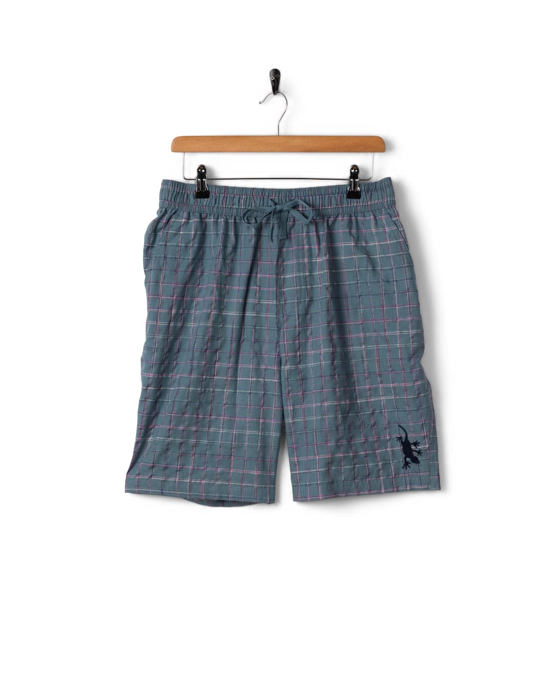 Plaid shorts on a hanger against a white background