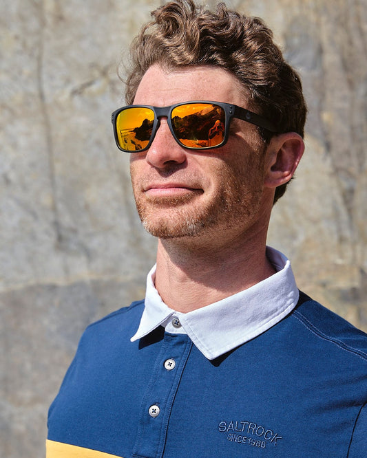 A man wearing sunglasses and a Saltrock Wesley - Men's Panelled Rugby Shirt - Blue.