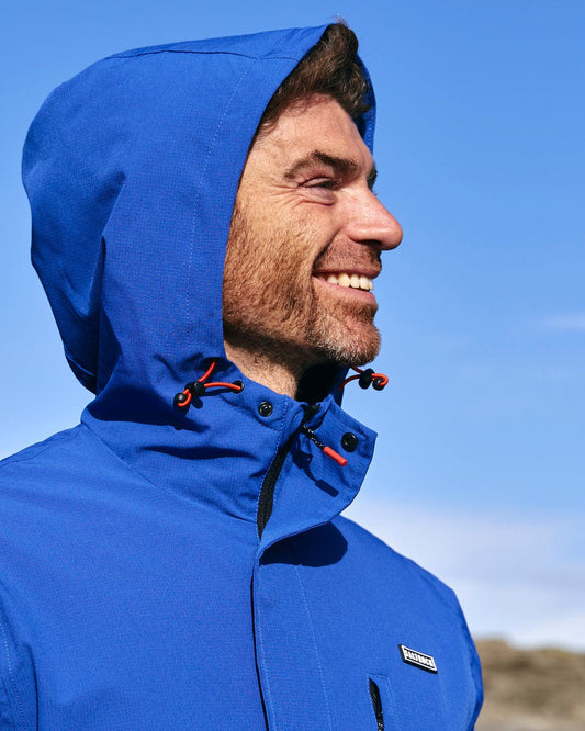 A man is smiling in a Saltrock Whistler - Mens Hooded Jacket - Blue.