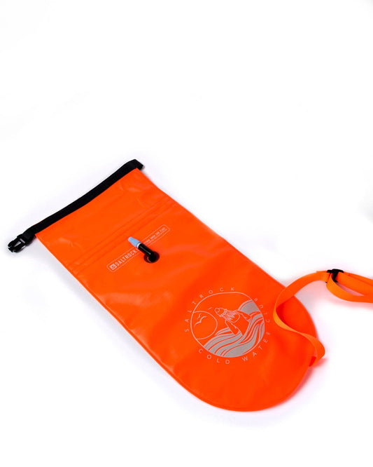 An orange Saltrock dry bag designed for cold water swimming, with a black zipper and strap on a white background.