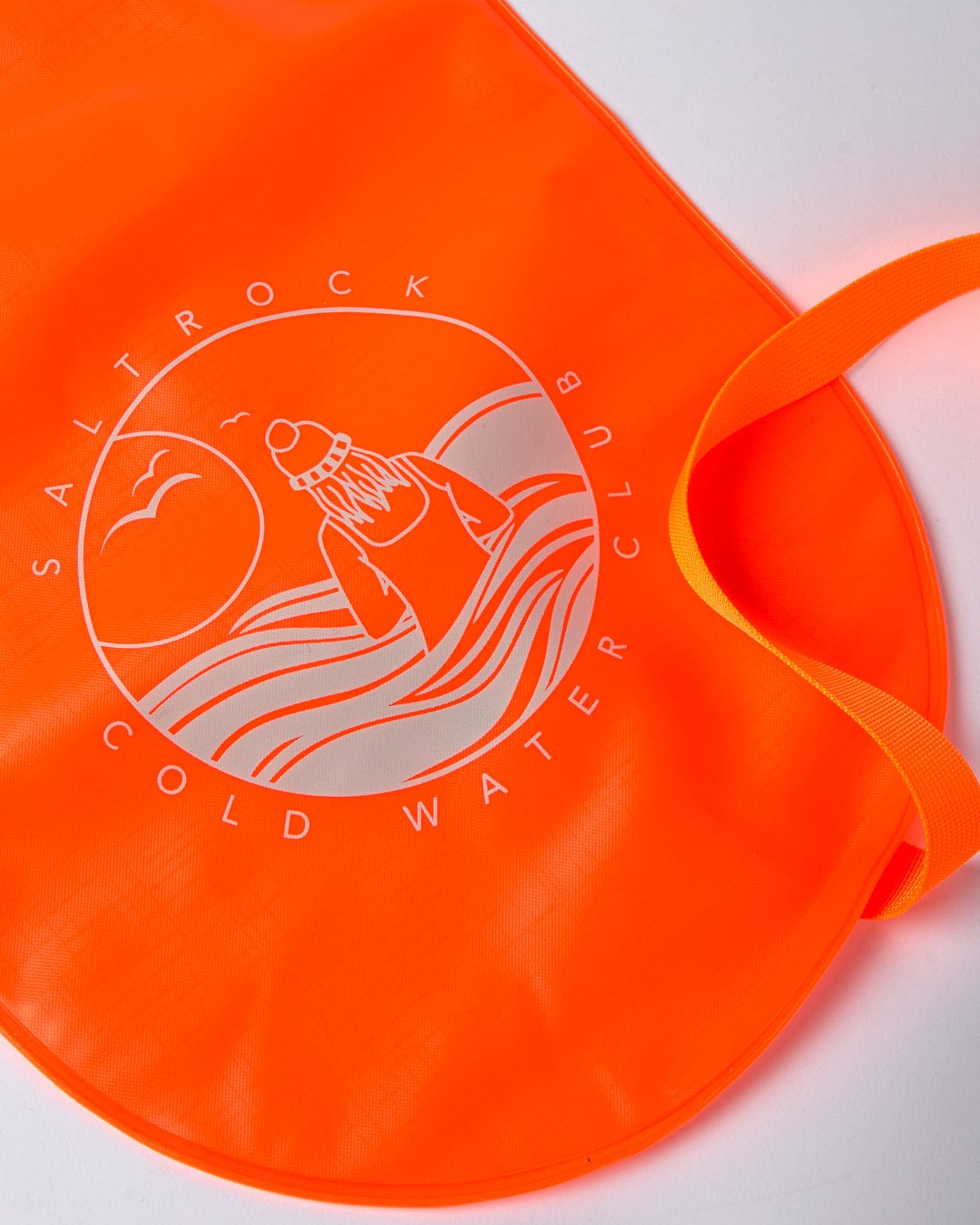 Bright orange Saltrock waterproof swim cap with "saltrock cold water club" logo on a white surface.