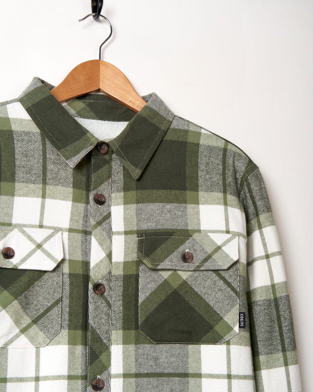 A Woody - Mens Borg Lined Shacket - Green Check shirt by Saltrock, hanging on a hanger.