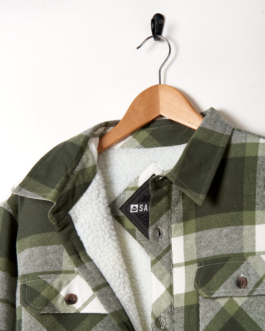 A Woody - Mens Borg Lined Shacket - Green Check by Saltrock hanging on a hanger.
