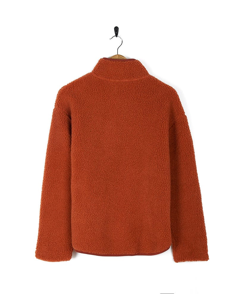 A Saltrock Zella Solid - Womens Borg Fleece - Burnt Orange sweater hanging on a hanger.