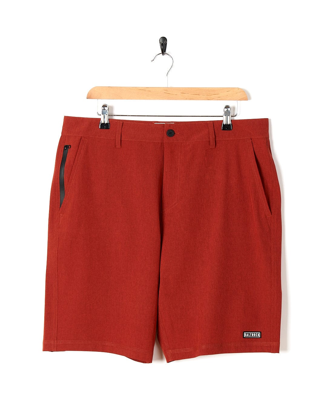 A pair of Saltrock Amphibian II - Mens Boardshort - Red hanging on a hanger.