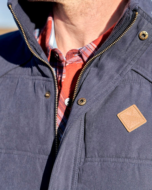 The man is wearing a Saltrock Bardsey - Mens Gilet with a hood, perfect for the season.