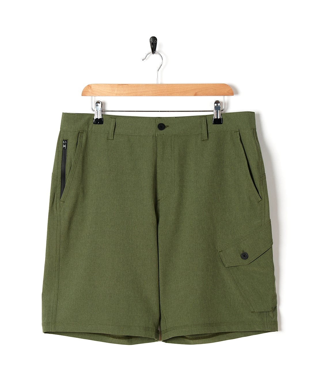 A pair of essential men's shorts, the Cargo Amphibian II - Mens Boardshort - Dark Green by Saltrock, hanging on a hanger.