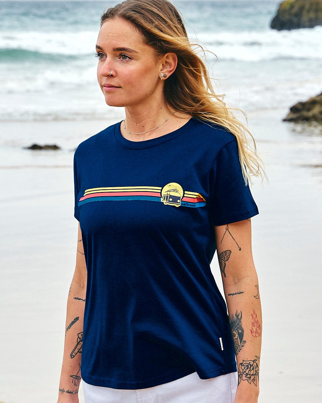 A woman standing on the beach wearing a Saltrock Celeste Stripe - Womens Short Sleeve T-Shirt - Blue.